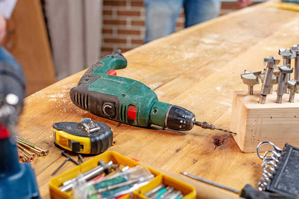 taladro taller de carpintería y otras herramientas se encuentran sobre la mesa
 - Foto, Imagen