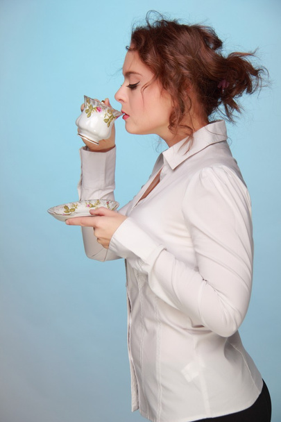 Woman drinking from a cup of coffee - Foto, imagen