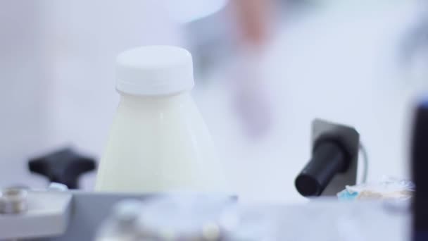 Proces tvorby mléka. Etiketovací stroj na výrobní lince. Označování produktů - Záběry, video