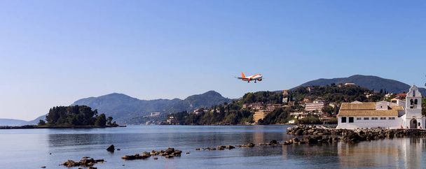 Widok na morze i chrześcijańskiej, prawosławny klasztor Vlacherna oddalony od Panayía, lecimy samolotem i Mouse island (Grecja, Wyspa Corfu) na da sunny wiosna - Zdjęcie, obraz