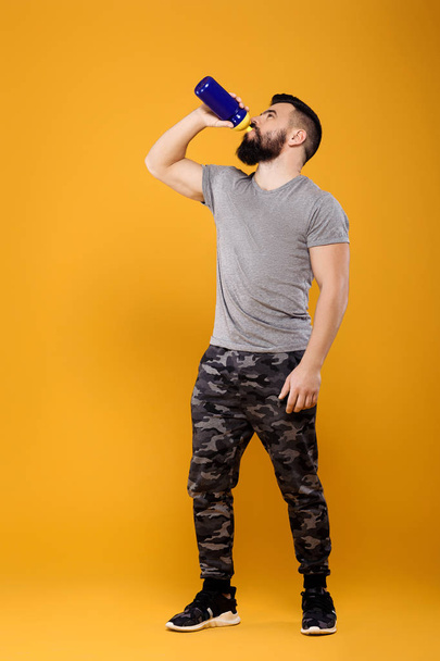 Handsome strong man drinks water - Foto, Imagen