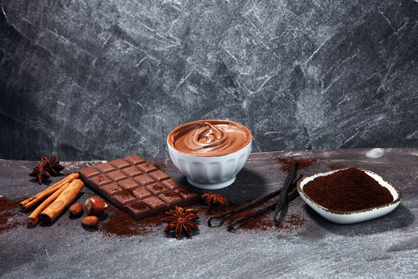 Schokoriegel auf dem Tisch mit Schokoladenpuder. Schokolade und Nüsse - Foto, Bild