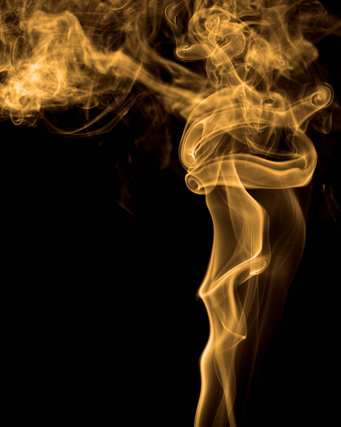 Un humo teñido retorciéndose patrones de clubes contra fondo negro
 - Foto, imagen