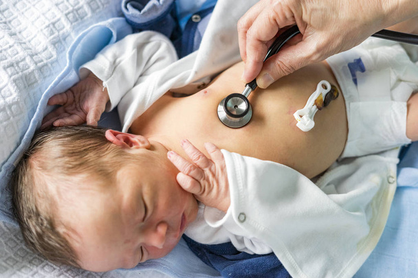 Sztetoszkóp segítségével ellenőrizni egészségügyi újszülött fiú a kórházban - Fotó, kép