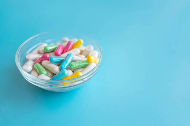 Nootropics, smart drugs, cognitive enhancers, compounds enhance brain function, Improve memory, cognitive and particularly executive functions. Multicolored capsules in female hand on blue background - Foto, afbeelding