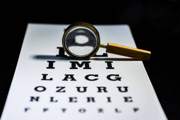 Una lente d'ingrandimento sul grafico del test dell'occhio, da vicino
 - Foto, immagini