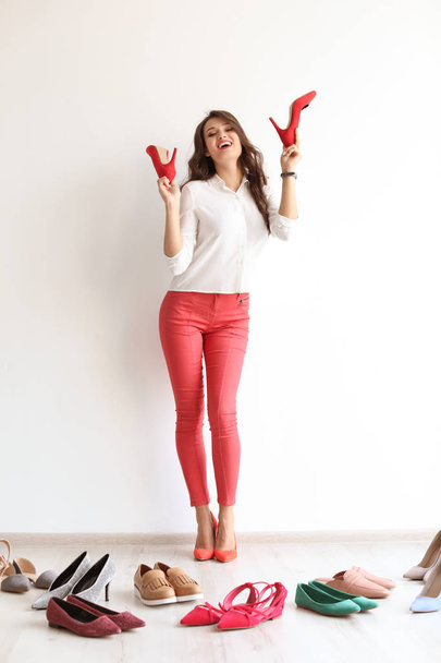Young woman with many beautiful shoes indoors - Foto, Imagen
