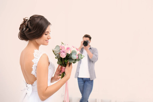 Professional photographer taking photo of beautiful bride in studio - Photo, image
