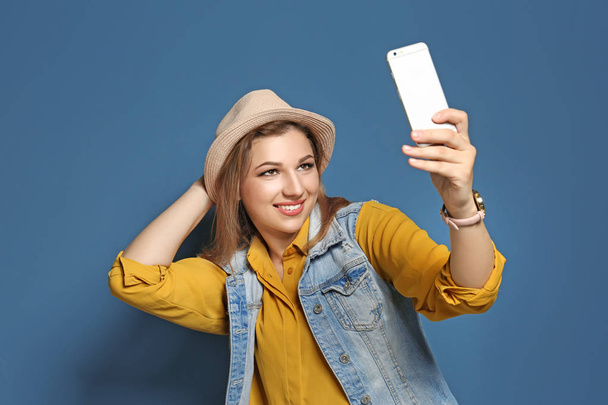 Attractive young woman taking selfie on color background - Foto, Imagem