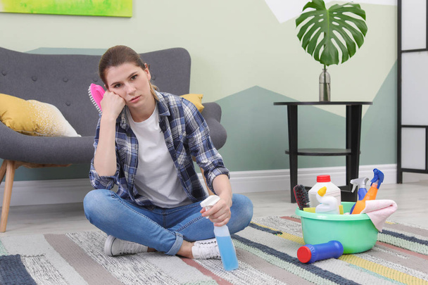 Tired woman having break while cleaning carpet with brush at home - Photo, Image