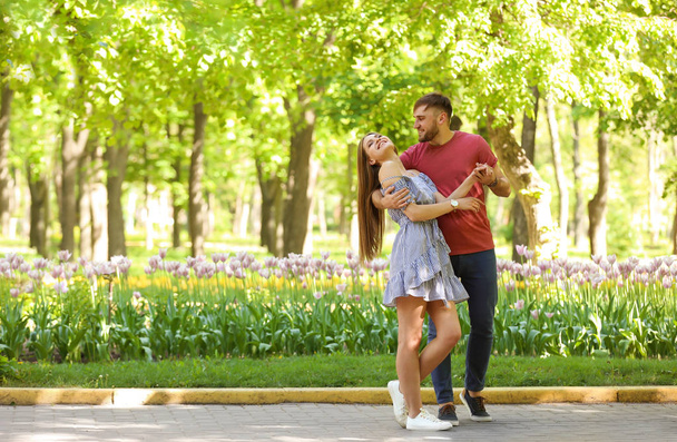 Happy young couple in green park on sunny spring day - Φωτογραφία, εικόνα