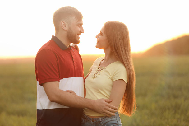 Happy young couple in green field on sunny spring day - Foto, Imagen