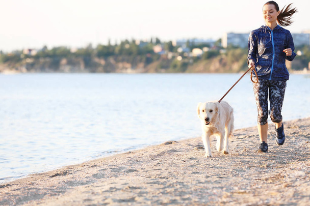 Young woman with her dog together on beach. Pet care - Foto, Imagem