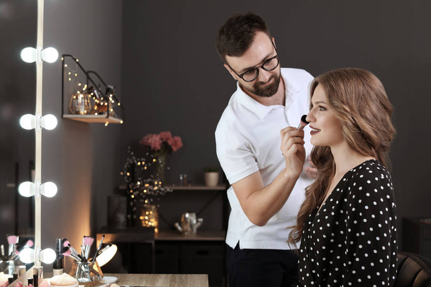 Professional makeup artist working with client in dressing room - Valokuva, kuva