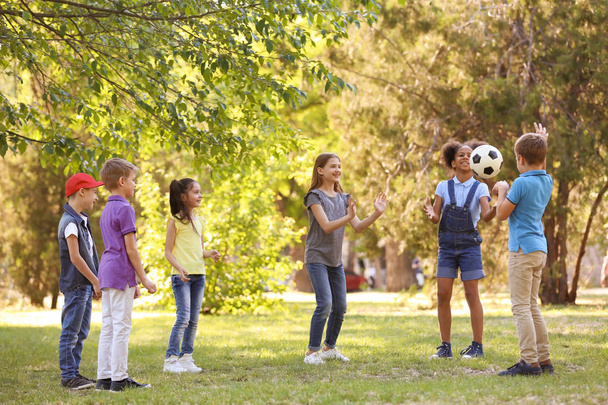 Bonito crianças brincando com bola ao ar livre no dia ensolarado
 - Foto, Imagem