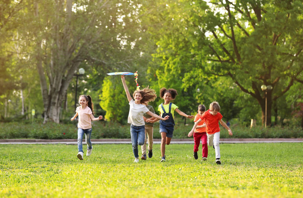 Petits enfants mignons jouant avec cerf-volant en plein air le jour ensoleillé
 - Photo, image