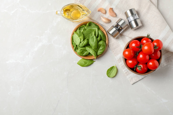 Flat lay composition with tomatoes, oil and basil on light background - Valokuva, kuva