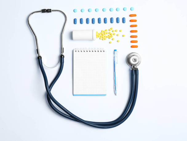 Flat lay composition with medical equipment and pills on light background - Φωτογραφία, εικόνα