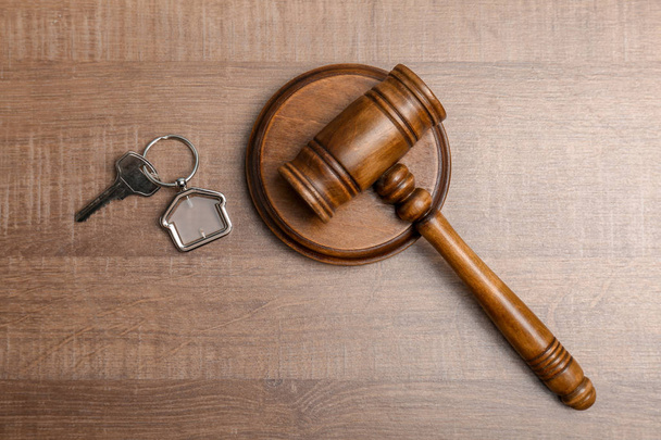 Judge gavel and house key on wooden background, top view. Estate law concept - Foto, Bild