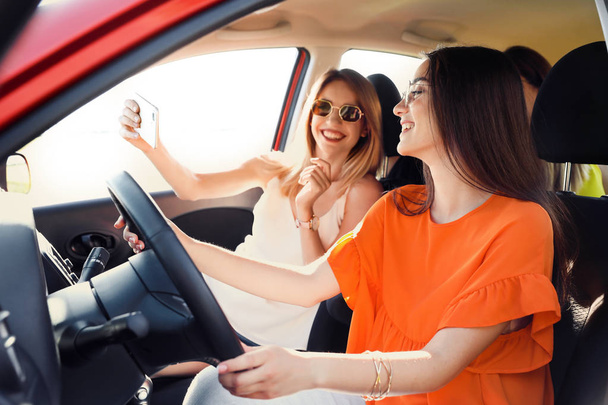 Ευτυχισμένος όμορφες νεαρές γυναίκες λήψη selfie σε αυτοκίνητο - Φωτογραφία, εικόνα