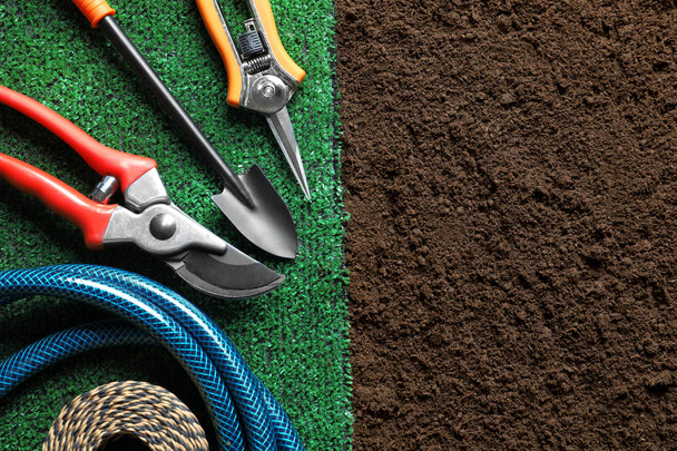 Flat lay composition with gardening tools and artificial grass on soil - Foto, Imagem