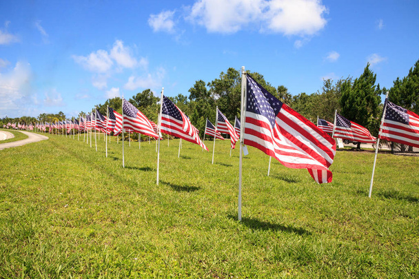 Πατριωτικό απεικόνιση των πολλών κυμάτων μεγάλες αμερικανικές σημαίες στον άνεμο κατά τη διάρκεια των διακοπών. - Φωτογραφία, εικόνα