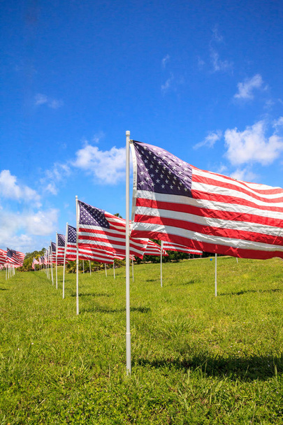 Patriotyczne wyświetlacz fali kilka dużych amerykańskich flag na wietrze podczas wakacji. - Zdjęcie, obraz
