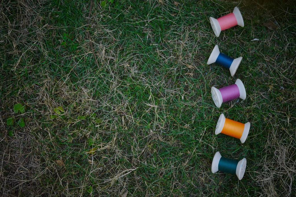 Bobines multicolores sur herbe verte pour le fond de couture
 - Photo, image