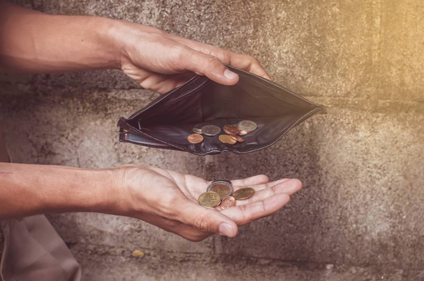 Siyah bir cüzdan ve küçük para tutan elini yakın çekim - Fotoğraf, Görsel