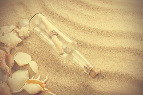 Message in bottle on the beach. Summer background with hot sand, in vintage style - Foto, immagini