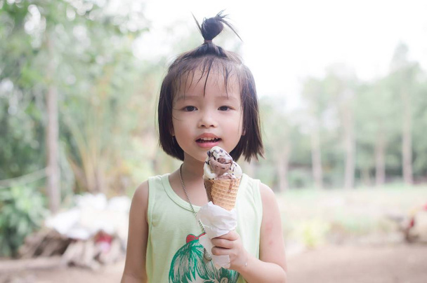 Ładna dziewczyna, cieszyć się jedzeniem topnienia lodów czekoladowych - Zdjęcie, obraz
