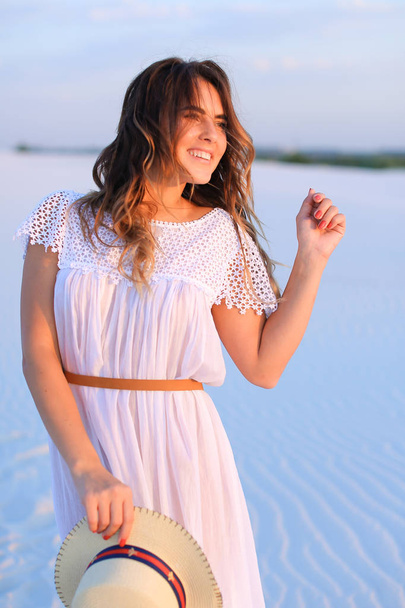 Young smiling female person standing on white sand, wearing dres - Photo, Image