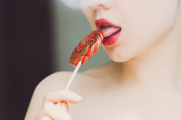 Seductive female licking lollipop - Фото, изображение