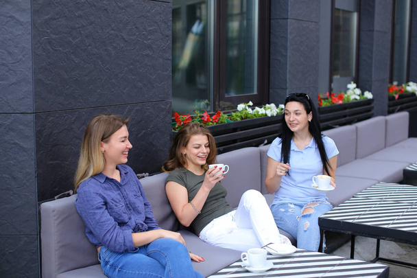 Mujeres amigas positivas riéndose de la cafetería y chismorreando, bebiendo café
. - Foto, Imagen