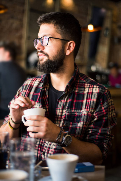 Bearded hipster man in a coffee bar - Photo, Image