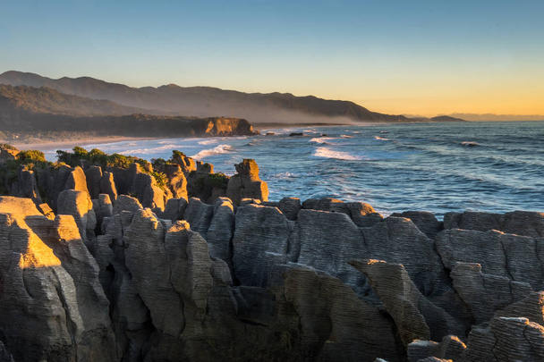 Zonsondergang in Punakaiki pannenkoek rotsen en blowholes in de west kust van Nieuw-Zeeland Zuid eiland - Foto, afbeelding