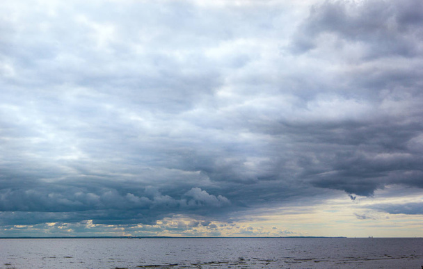 Панорамний вид на кумульські хмари та драматичне приглушене небо над морем та лінією горизонту
. - Фото, зображення