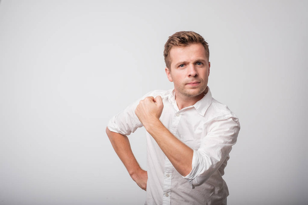 Hombre de mediana edad con confianza en sí mismo en camisa blanca con un puño cerrado
 - Foto, imagen