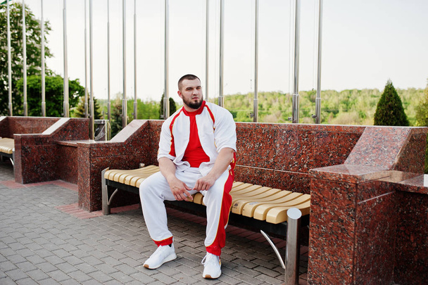 Young brutal bearded muscular man wear on white sport suit with red shirt. - Fotoğraf, Görsel