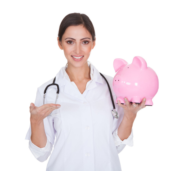 Young Female Doctor Holding Piggy Bank - Fotoğraf, Görsel
