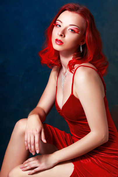 portrait of beautiful purple red haired girl with fantasy flame make-up in red dress - Photo, Image