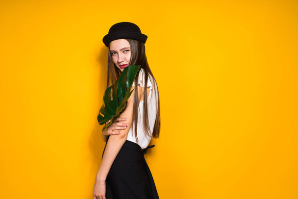 luxurious confident girl model in fashion hat posing on yellow background - Fotoğraf, Görsel