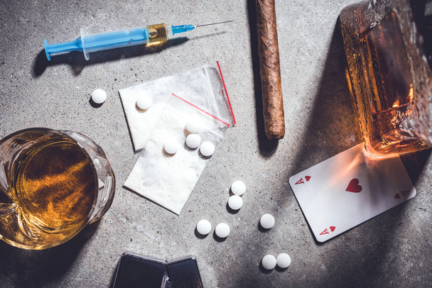 Hard drugs and alcohol on gray stone table. Top view - Foto, Imagen