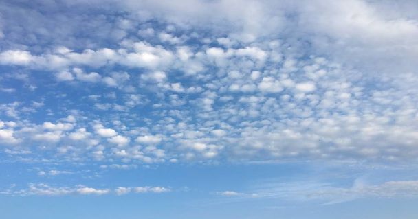 Prachtige wolken tegen de achtergrond van een blauwe hemel. Wolk lucht. Blauwe hemel met bewolkt weer, natuur wolk. Witte wolken, blauwe lucht en zon - Foto, afbeelding