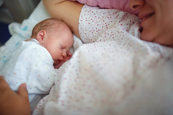 Newborn baby sleeps near mother - 写真・画像