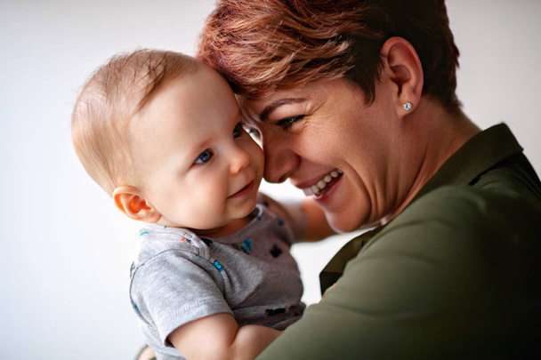 Tenderness between mom and male baby in her hands - Foto, Bild