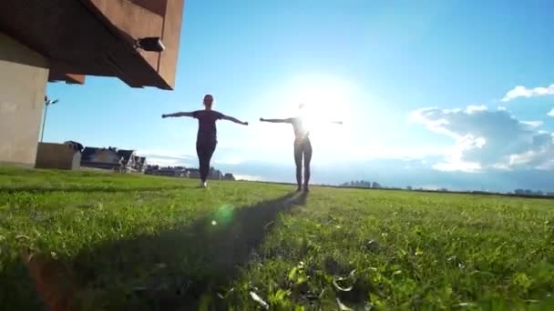 Twee vrouwelijke turnster training gelijktijdig bij zomer zonsondergang - Video