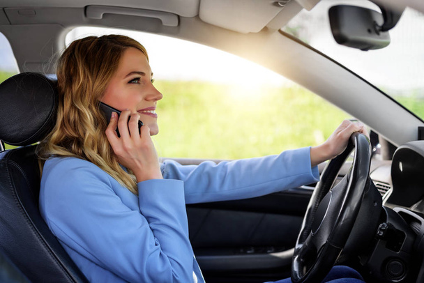 Vrouw spreekt op de telefoon in de auto. - Foto, afbeelding