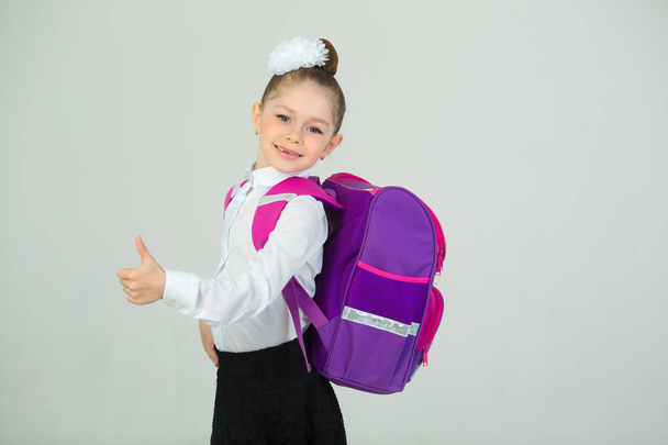 beautiful little girl with bow on head and with briefcase on white background - Valokuva, kuva