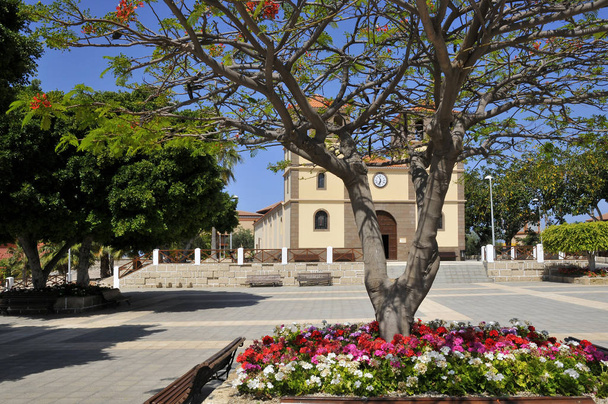 Church San Sebastian with flowers and royal poinciana (Delonix regia) on the costa Adeje of the southwest part of Tenerife in the Spanish Canary Islands           - Photo, Image
